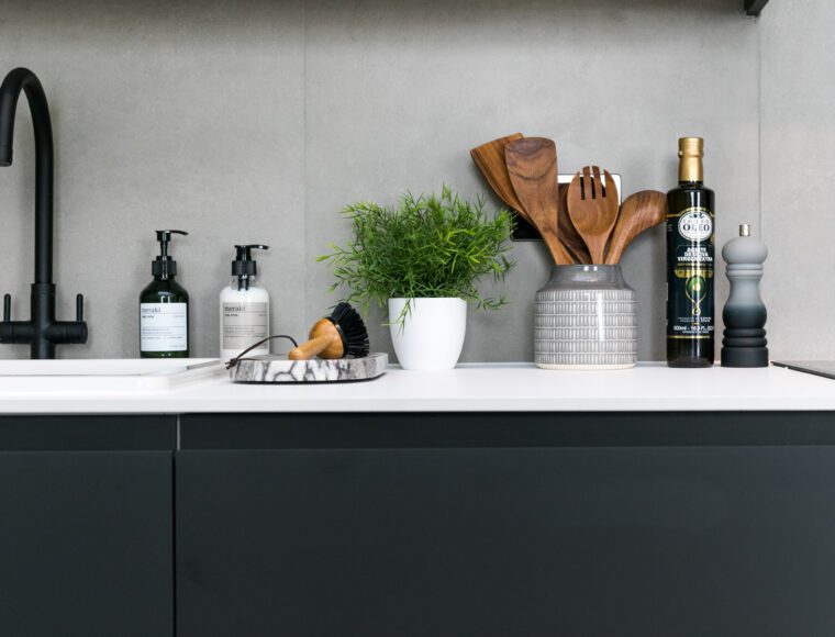 A close up of a kitchen counter, with kitchen amenities and cutlery.