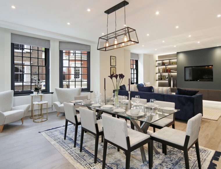 An open plan dining and living room, with glass dining furniture, and seating area