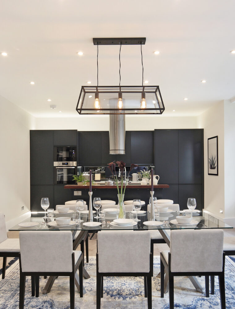 Dining area with an 8 seated table, and kitchen area. Property purchased by a London Buying Agent