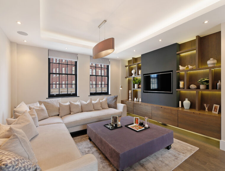 Lounge room with an L-shaped sofa, dining table and built in television.
