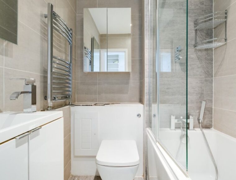 A bathroom with a shower and bathtub, with a towel rack and built in storage.
