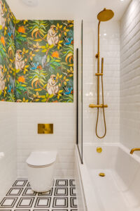 A tropical themed bathroom with a bath and shower.