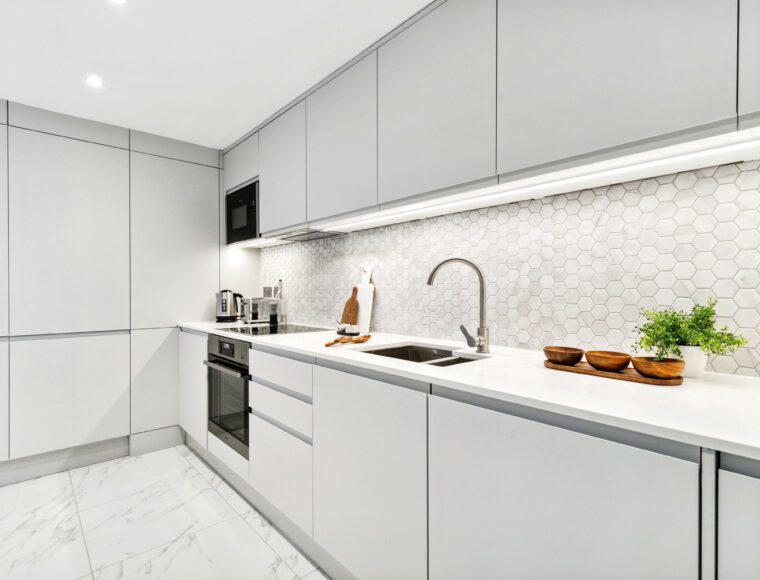 Modern kitchen in London with white cabinets and tiles